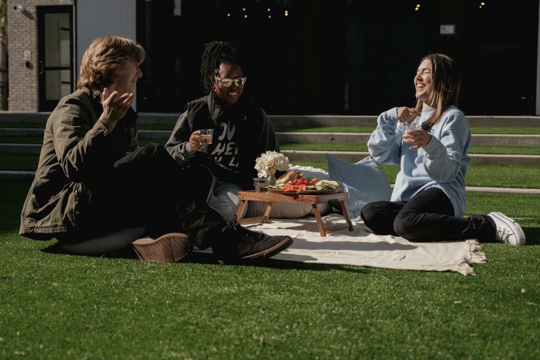 Tres personas compartiendo un picnic al aire libre Tres personas compartiendo un picnic al aire libre